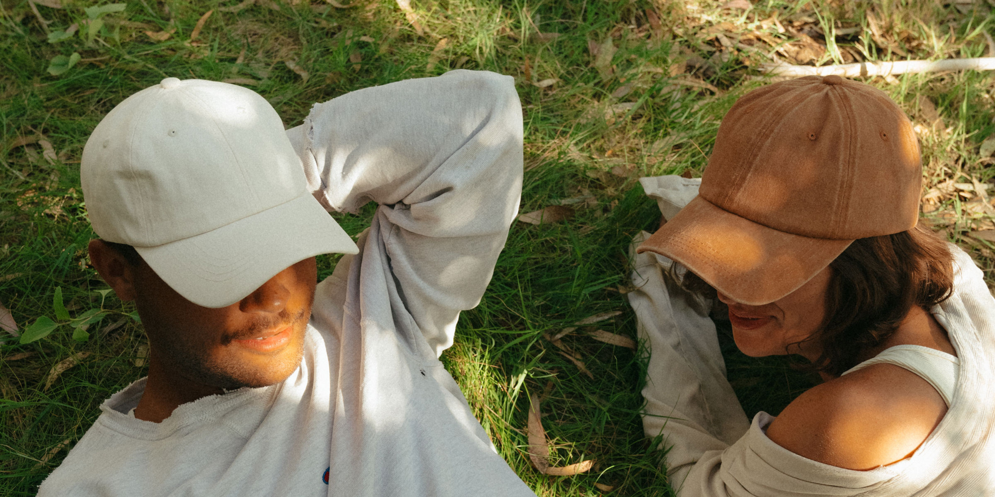 A man and woman both wearing nonbranded dad hats