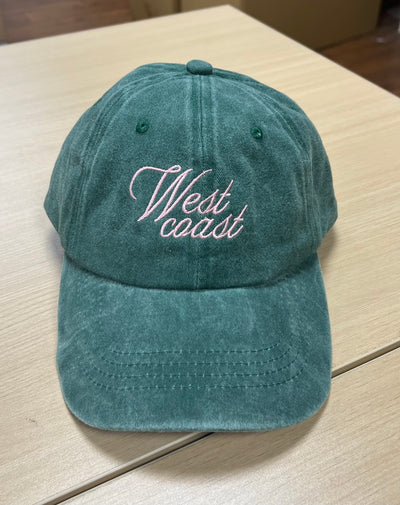 White West Coast script on a green Classic Cap