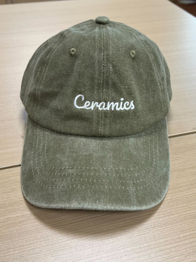 White Ceramics script on a green Classic Cap