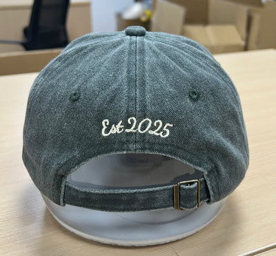 White Est 2025 script above the back opening of a green Classic Cap