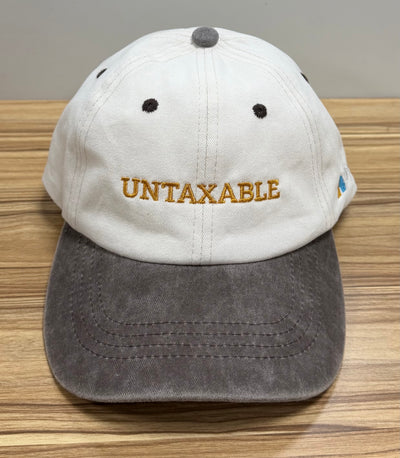 Gold Untaxable lettering on a white and charcoal Classic Cap