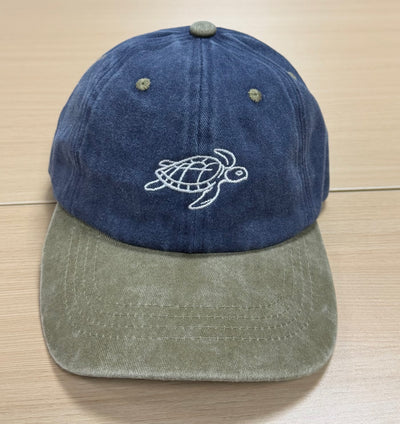 White turtle embroidery on a navy and olive Classic Cap